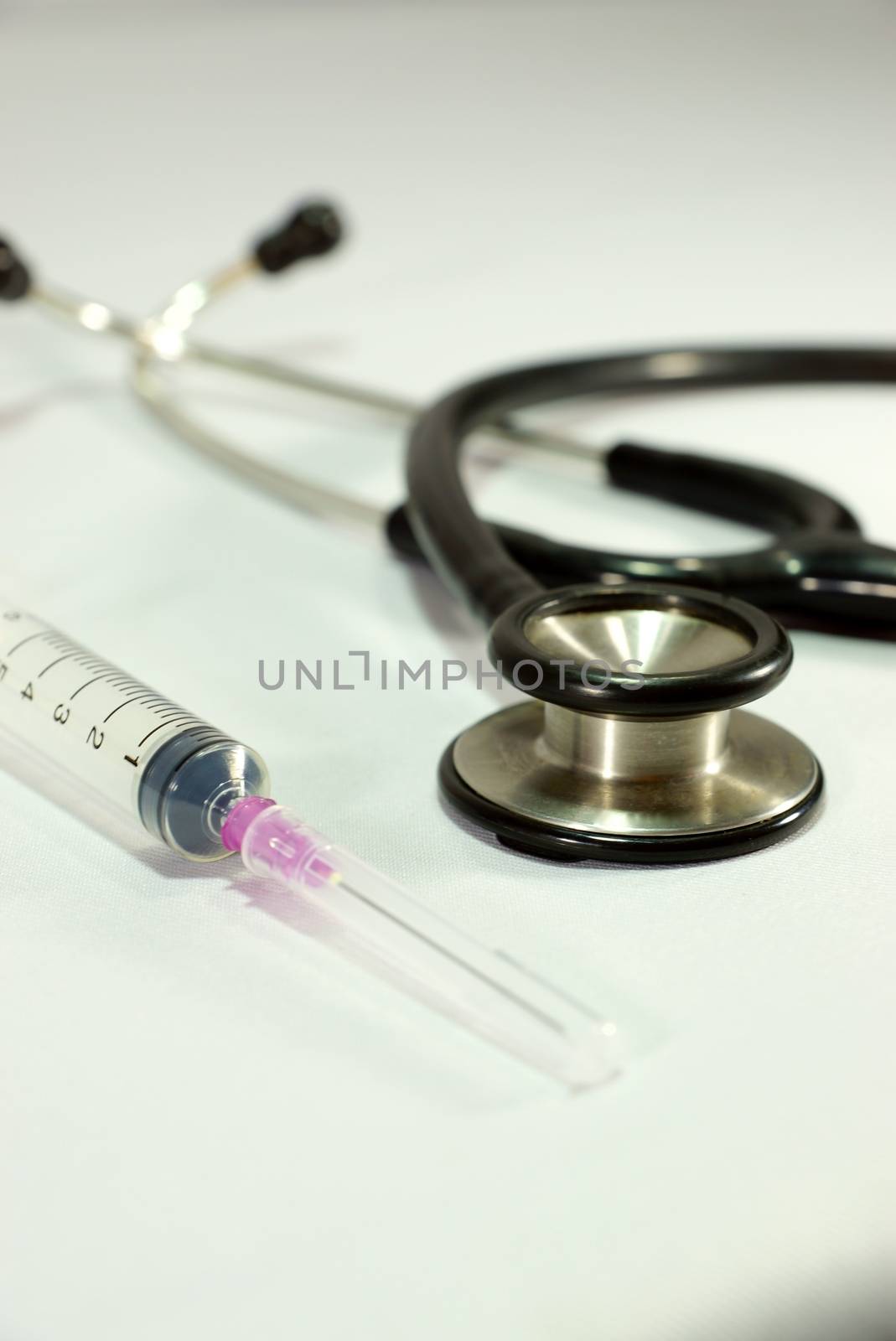 one black stethoscope and 5 cc syringe