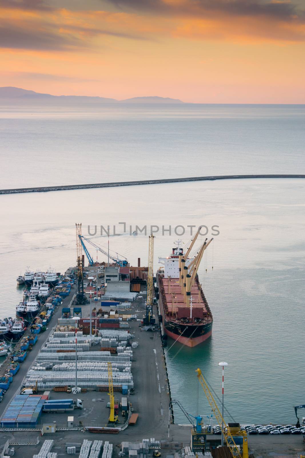 View of the busy harbor of Salerno, Italy, at sunrise with ships and containers on the dock