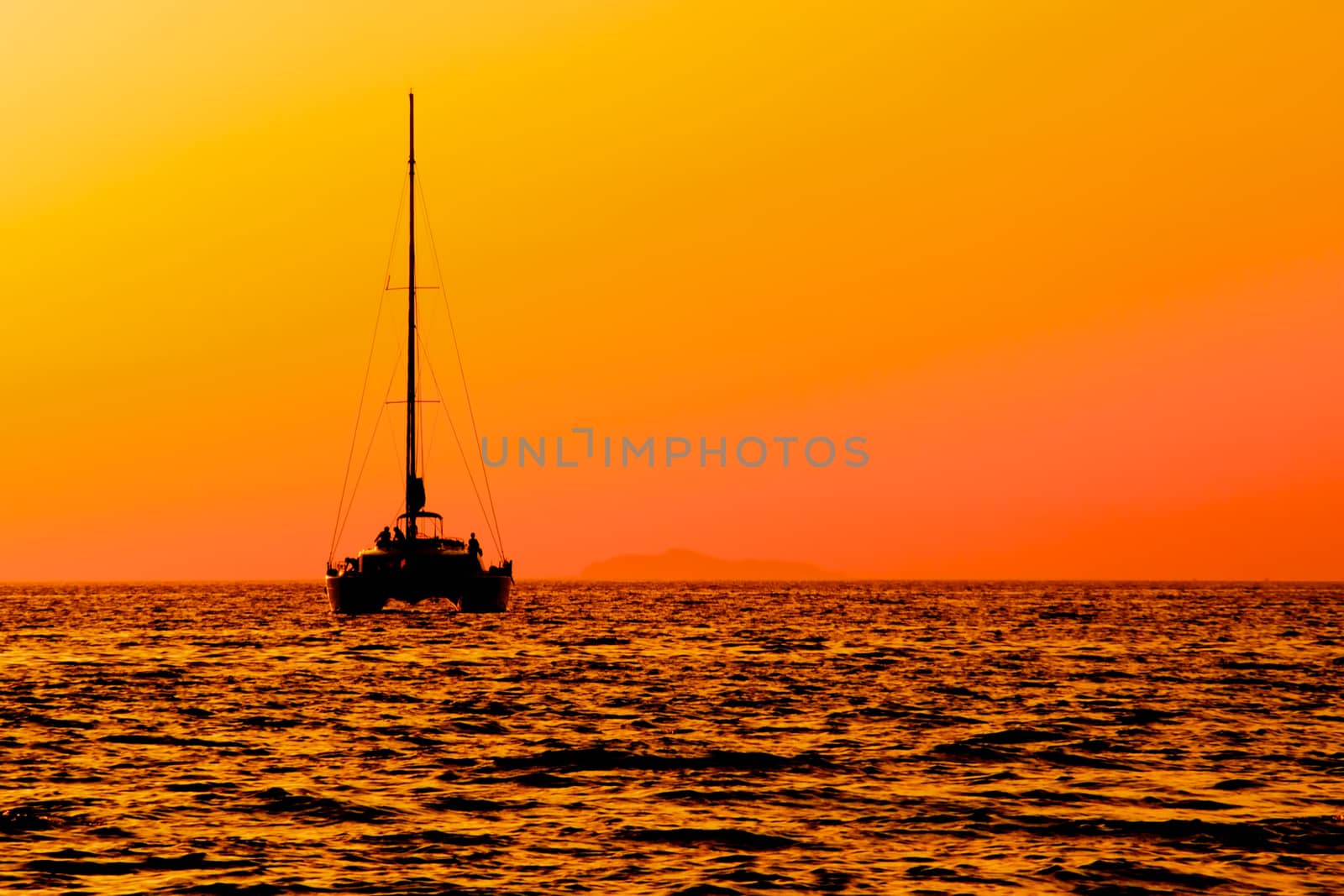View of a catamaran sailing at sunset towards the harbour of Acciaroli, southern Italy