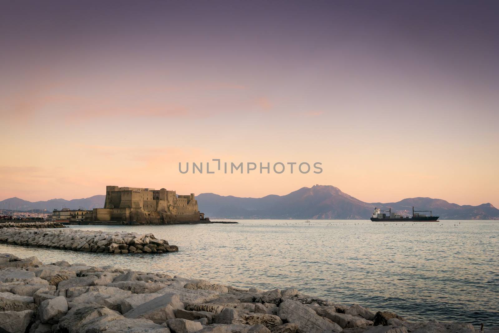View of Castel dell Ovo in Naples, an ancient fortress on the sea, at dusk