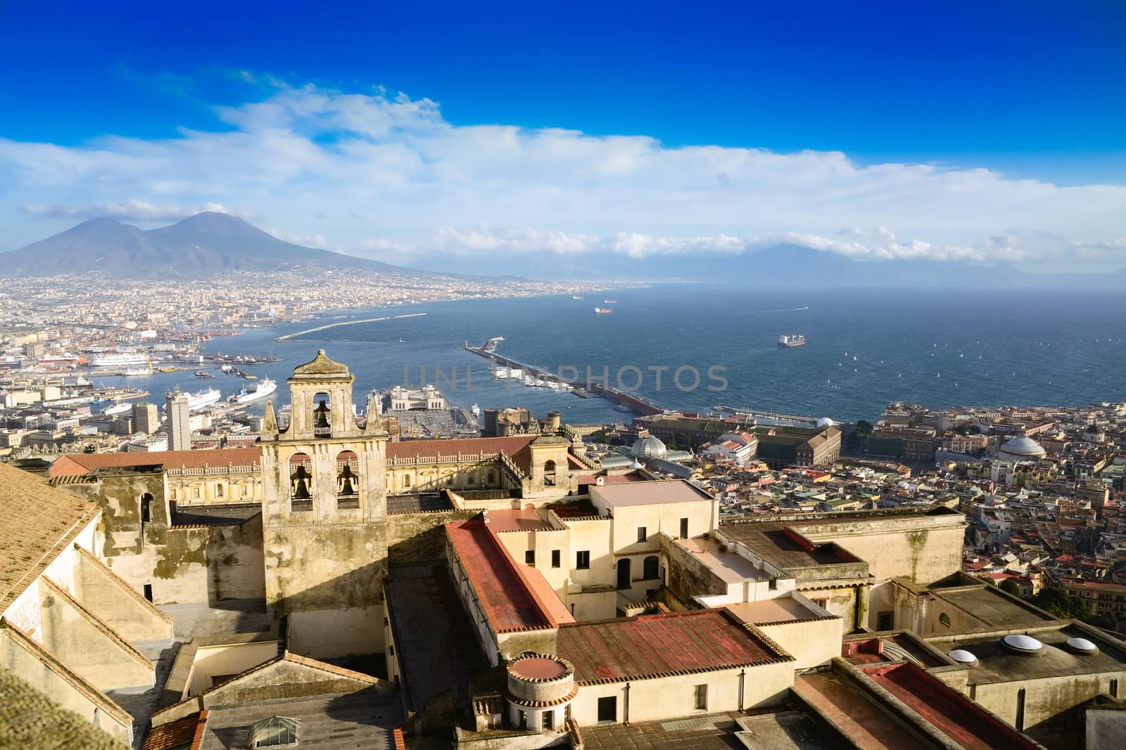 View of Gulf of Naples and Mount Vesuvius, with city harbor and monumental center, windy day.