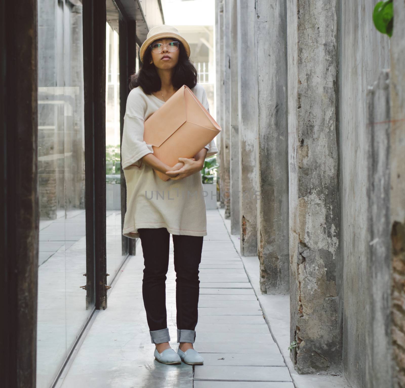 Young fashion girl with handbag at alleyway, retro filter