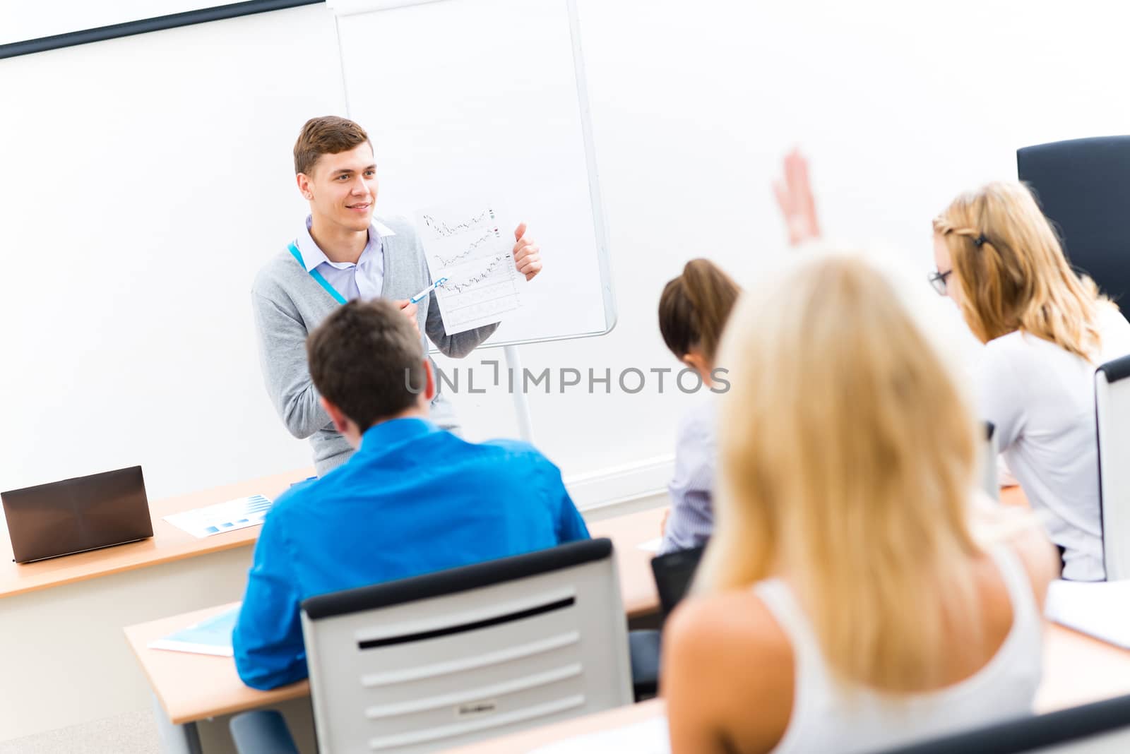 young teacher man talking with students in the classroom