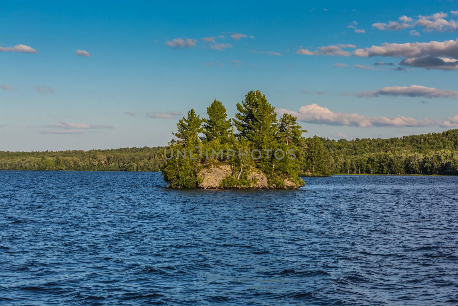 An amazing landcape of the nature containing a lake and a beautiful blue sky. The wild nature of Ontario, Canada.