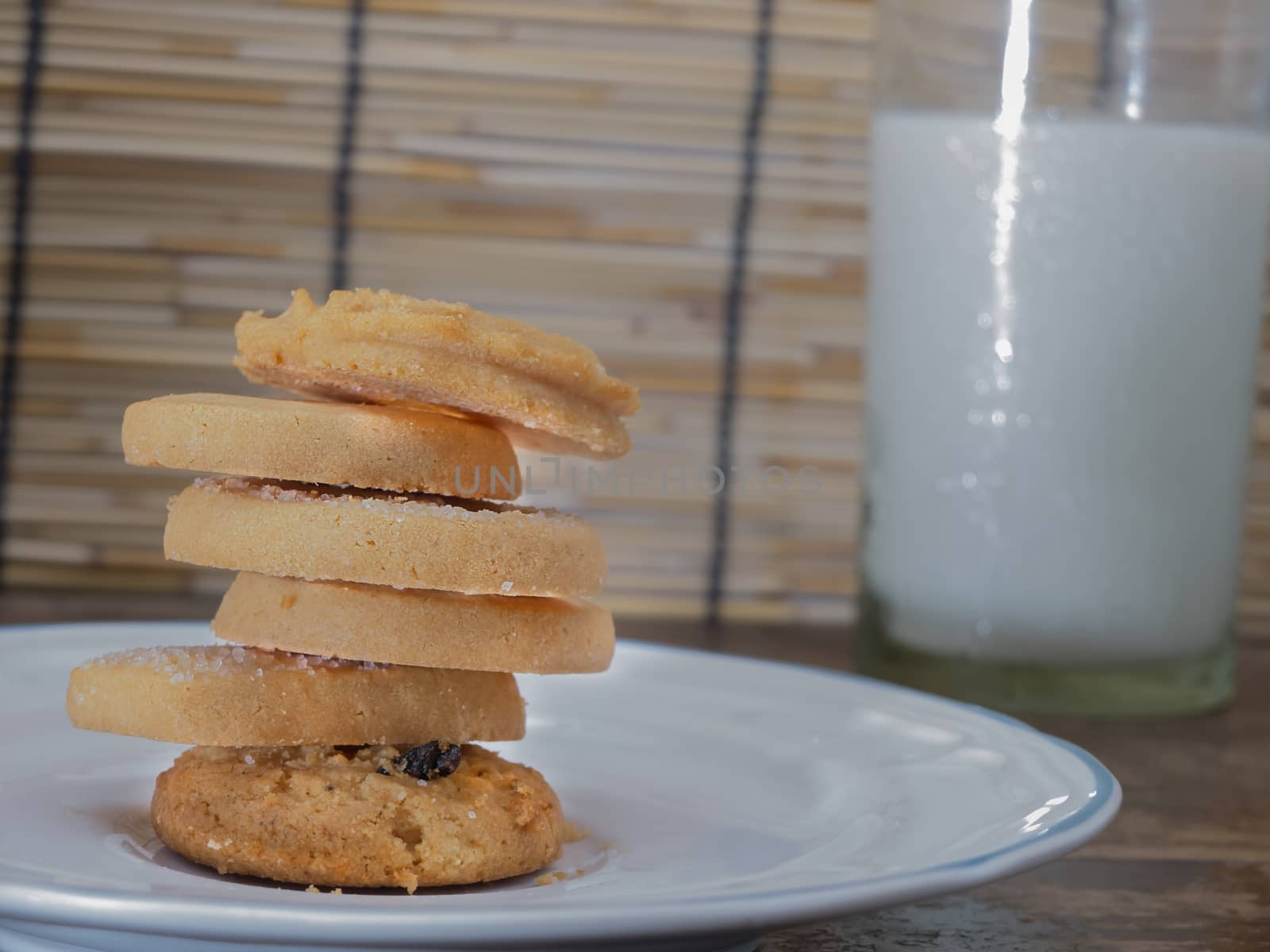 cookies multiple flavors, notebook, camera, milk on wooden table