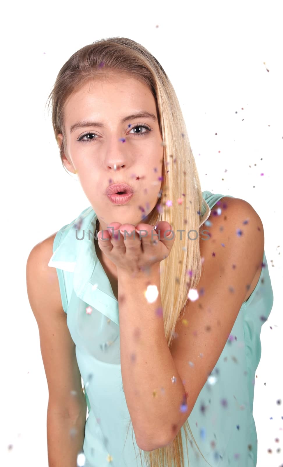Lovely young blond lady blowing confetti out of her hand