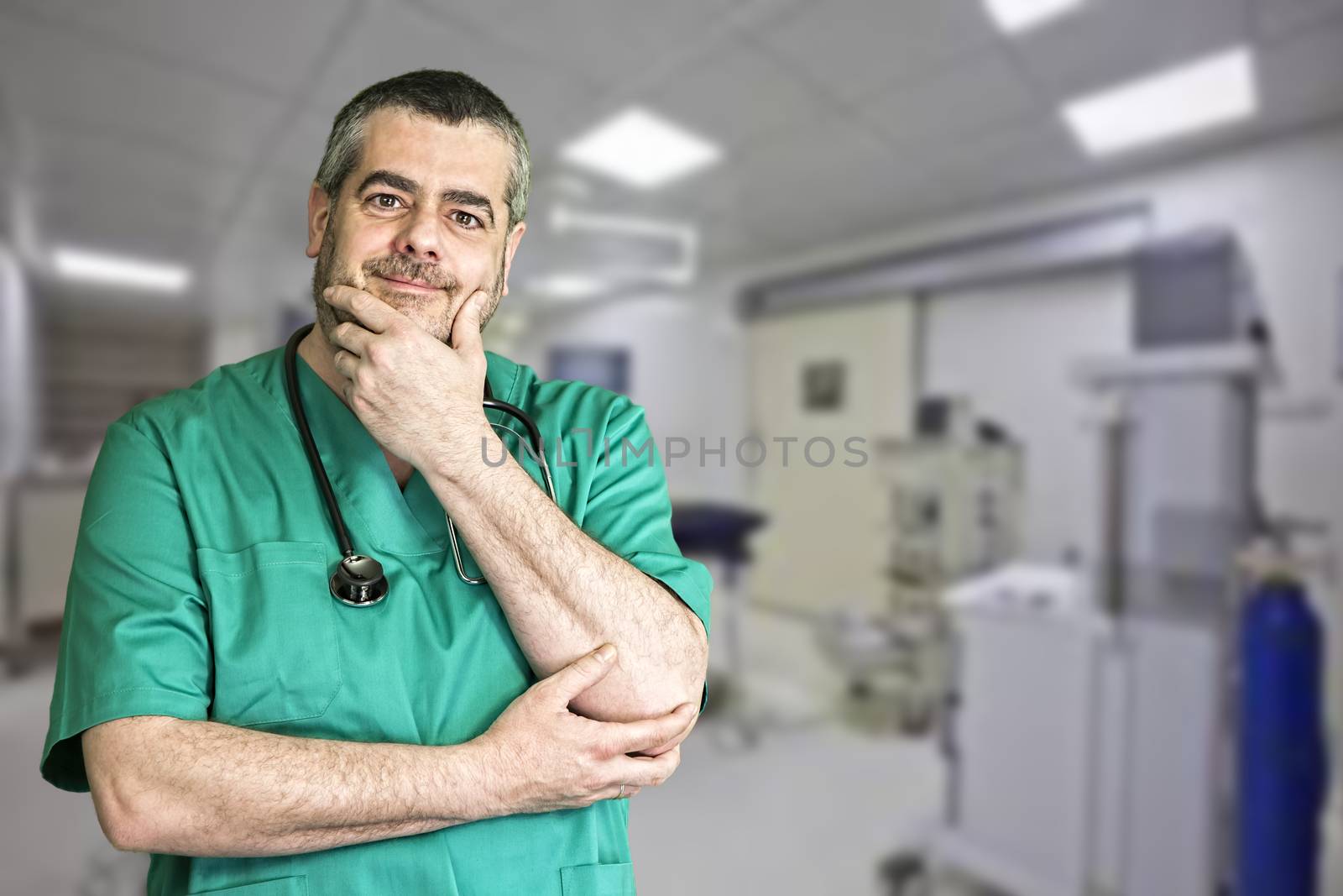 Smiling doctor with arms crossed in operating room