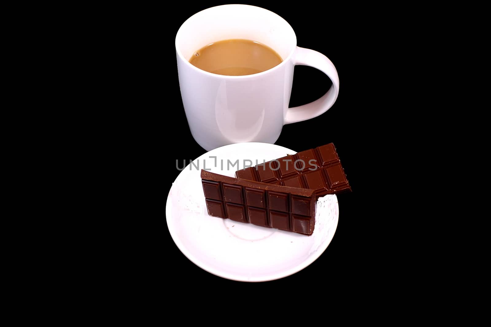 On a black background white cup of coffee stands and lies on a platter brown chocolate