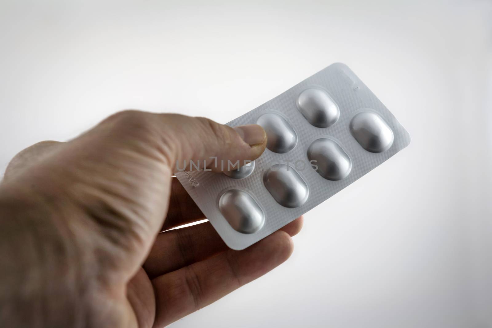 medical pills in a hand isolated on white background by digicomphoto