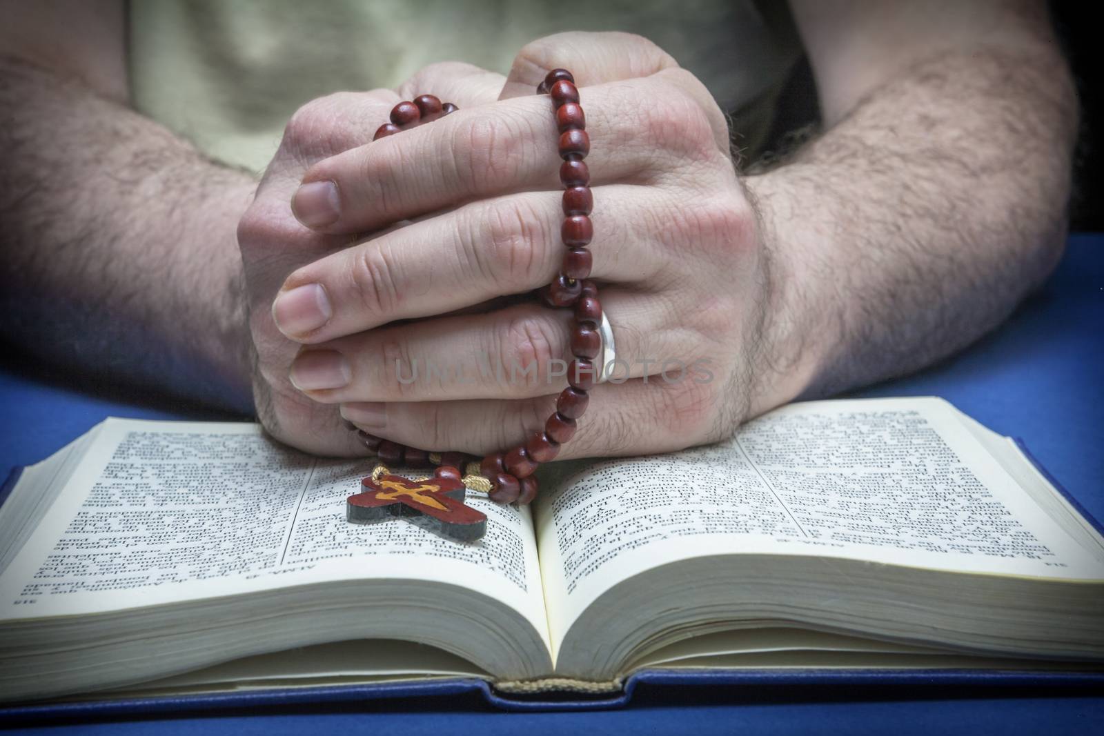 Christian believer praying to God with rosary in hand