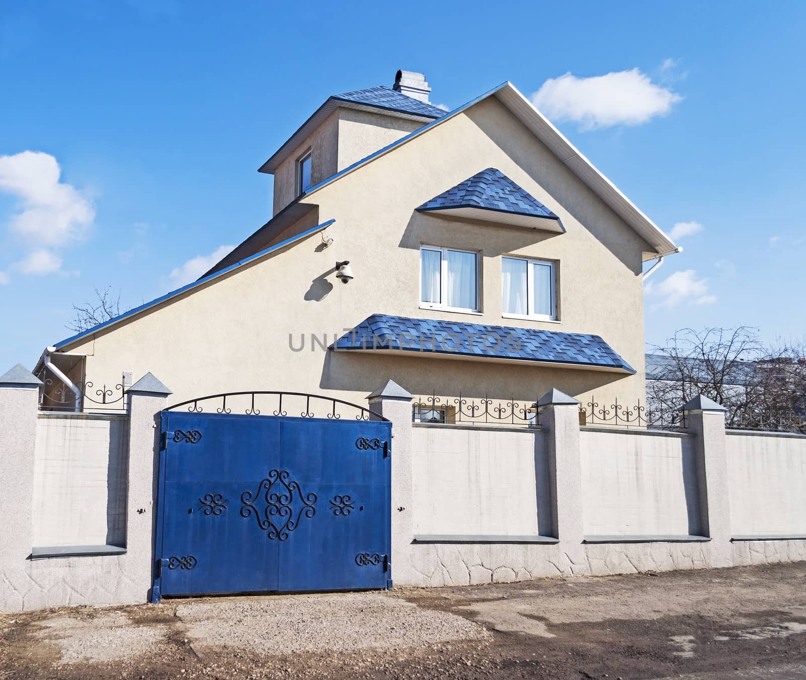 New country house with blue roof, sunny spring day