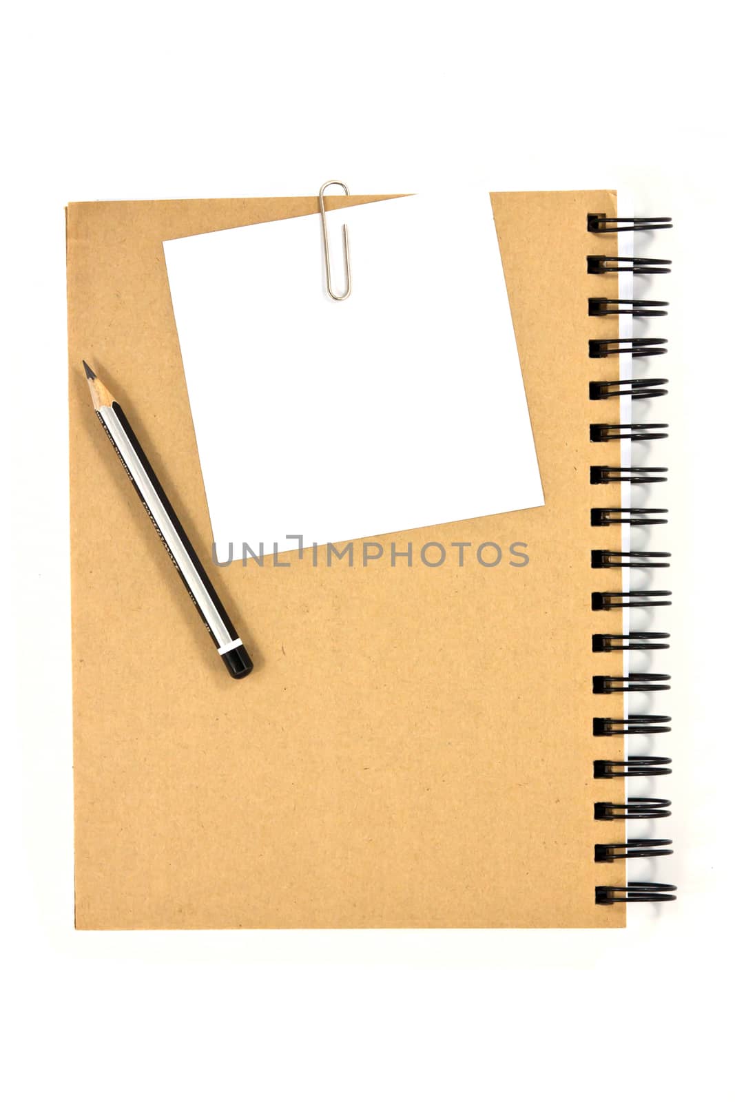 White note paper clip on brown cover note book with pencil