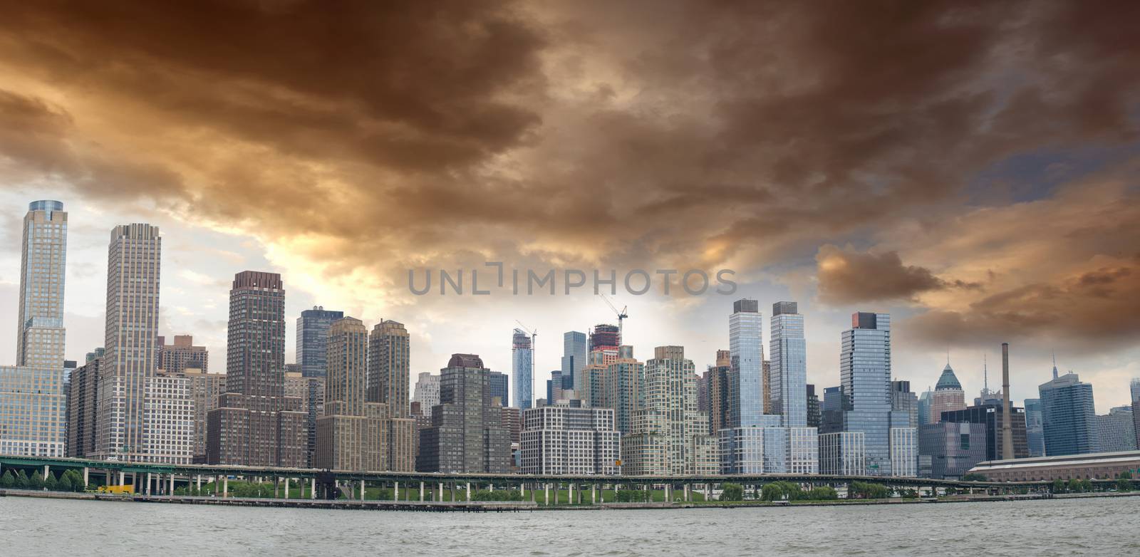 Panoramic view of Manhattan East Side with cloudy sky.