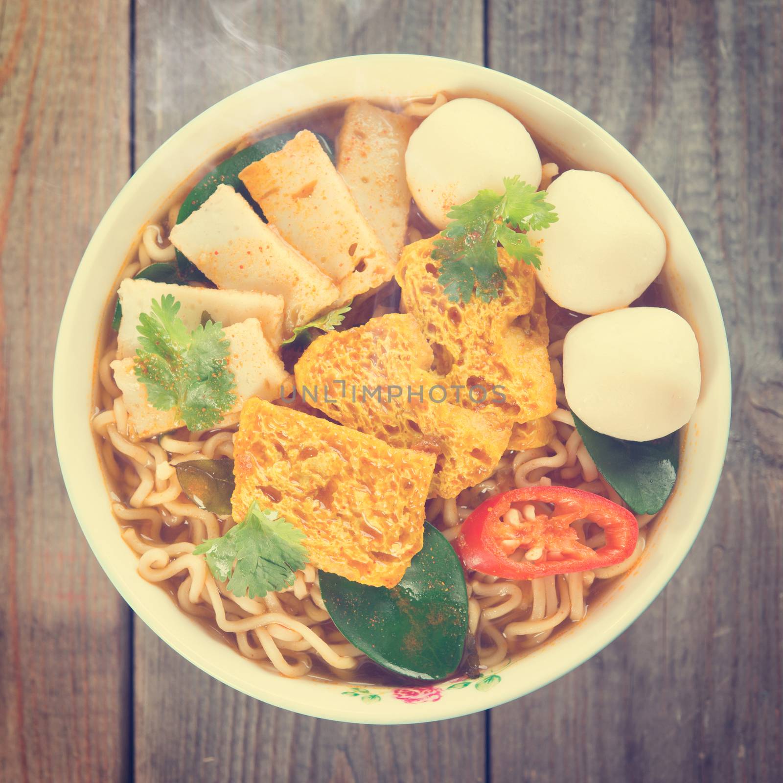 Spicy curry instant noodles soup in vintage revival retro style on wooden dining table. 