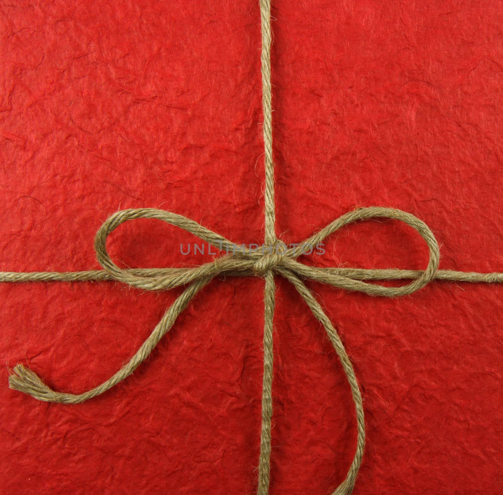 String tied in a bow on red paper