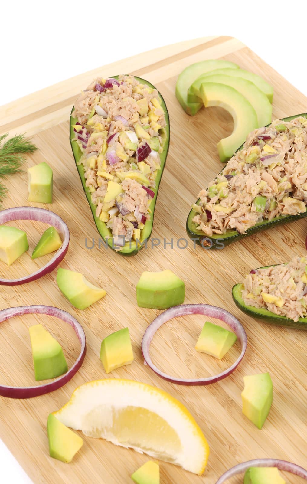 Avocado salad with tuna. Located on the wooden hardboard.