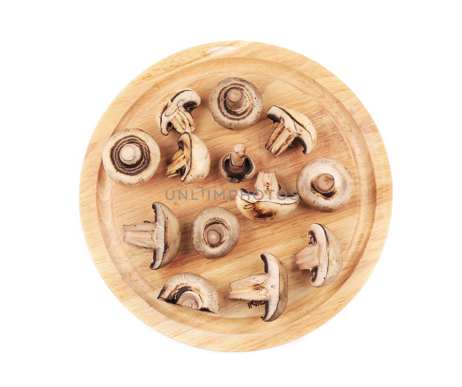 Mushrooms on wooden platter. Isolated on a white background.