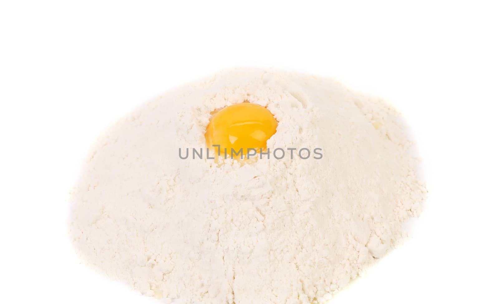 Yellow raw yolk on flour. Isolated on a white background.