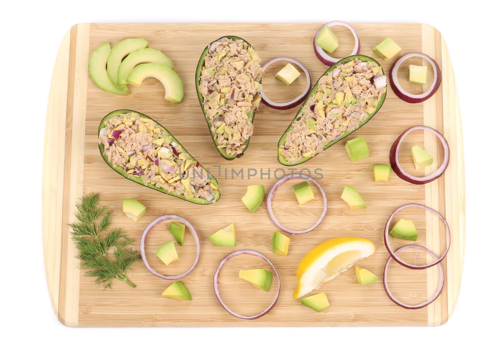 Avocado salad with tuna on cutting board. Isolated on a white background.