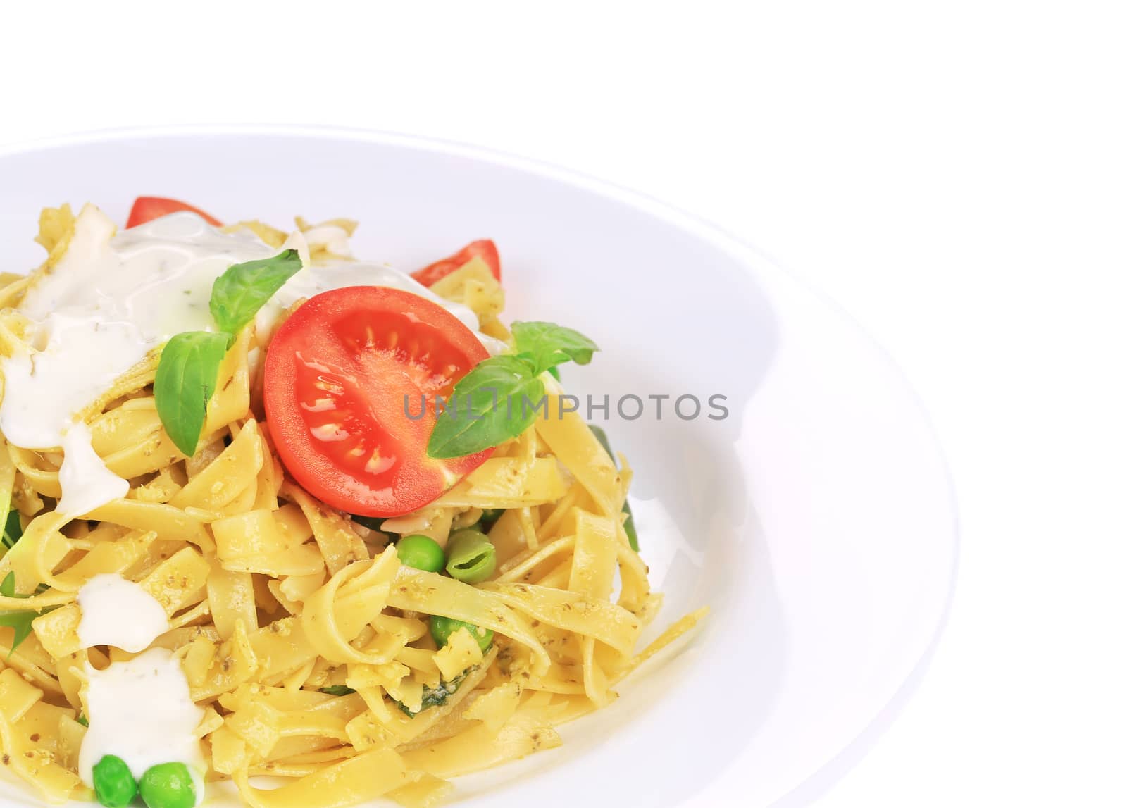 Pasta tagliatelle with pesto sauce and basil. Isolated on a white background.