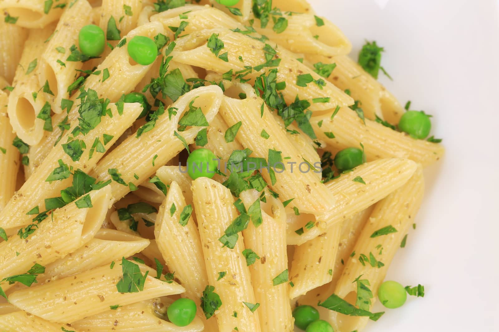 Pasta penne rigate with pesto sauce. Isolated on a white background.