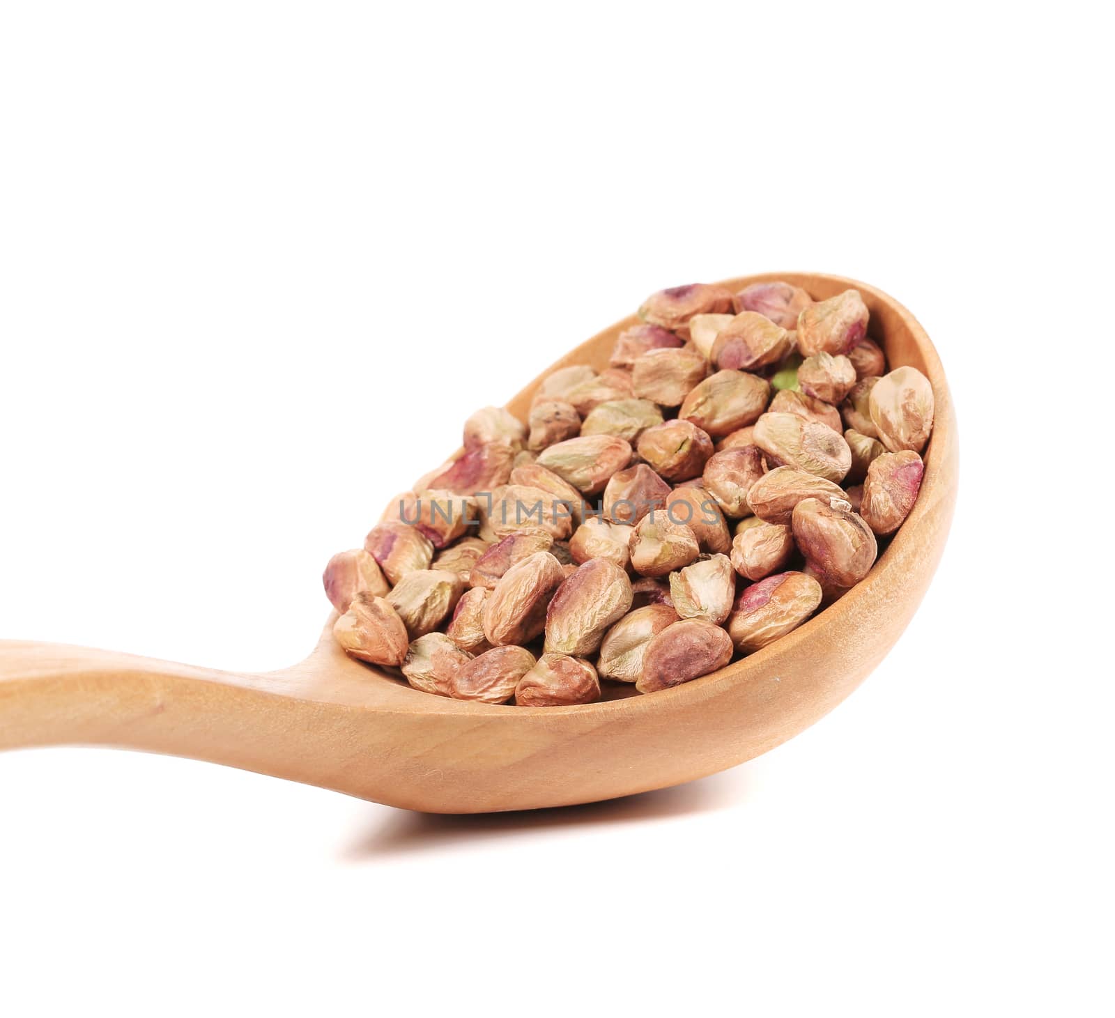 Wooden spoon with pistachios. Isolated on a white background.