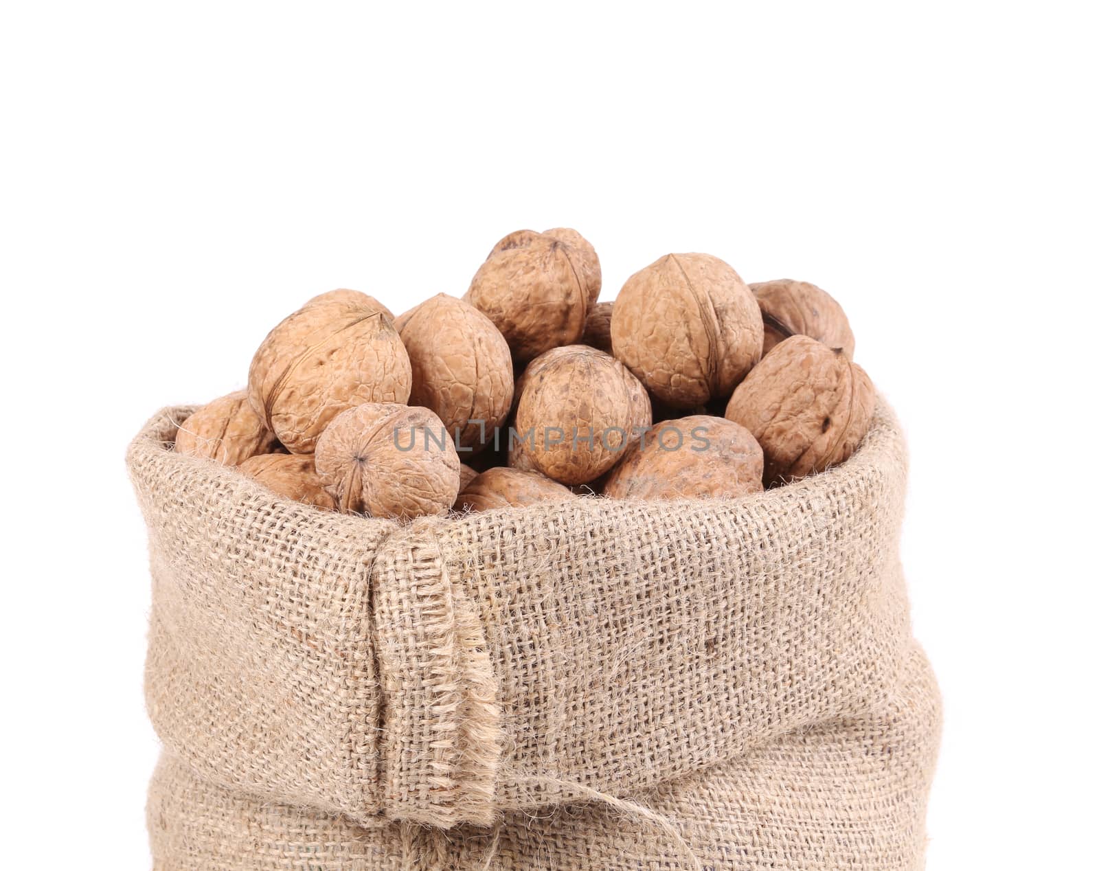 Walnuts in burlap bag. Isolated on a white background.