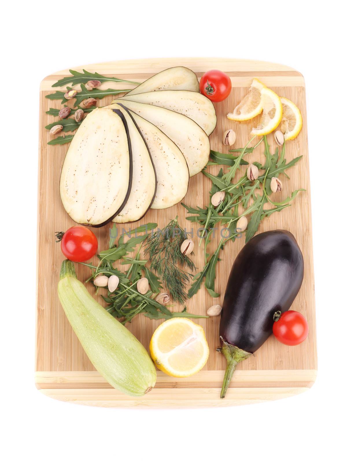 Vegetables with lemon on wooden platter. Isolated on a white background.
