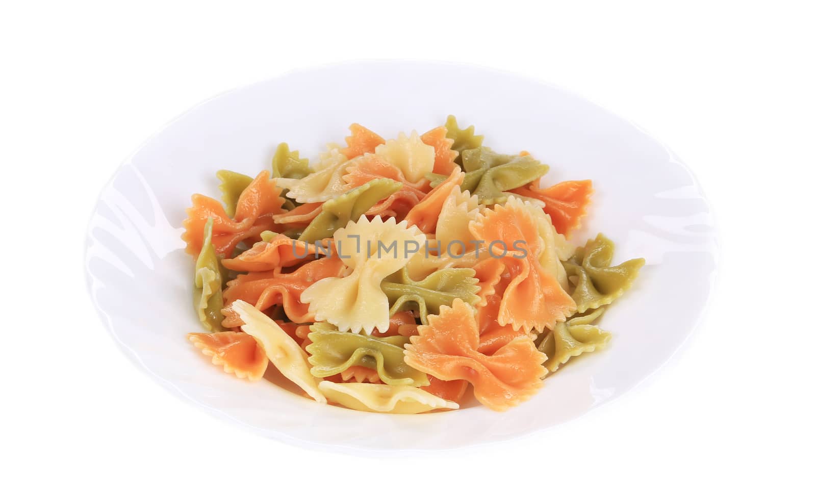 Colored farfalle on white plate. Isolated on a white background.