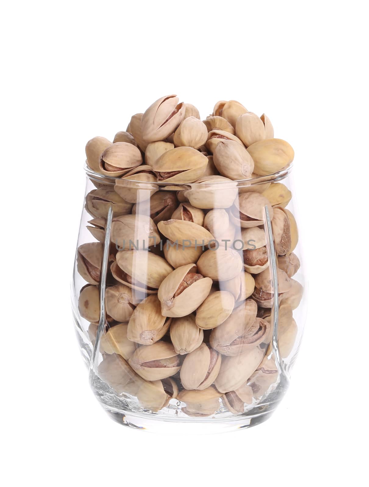 Water glass full of pistachios. Isolated on a white background.