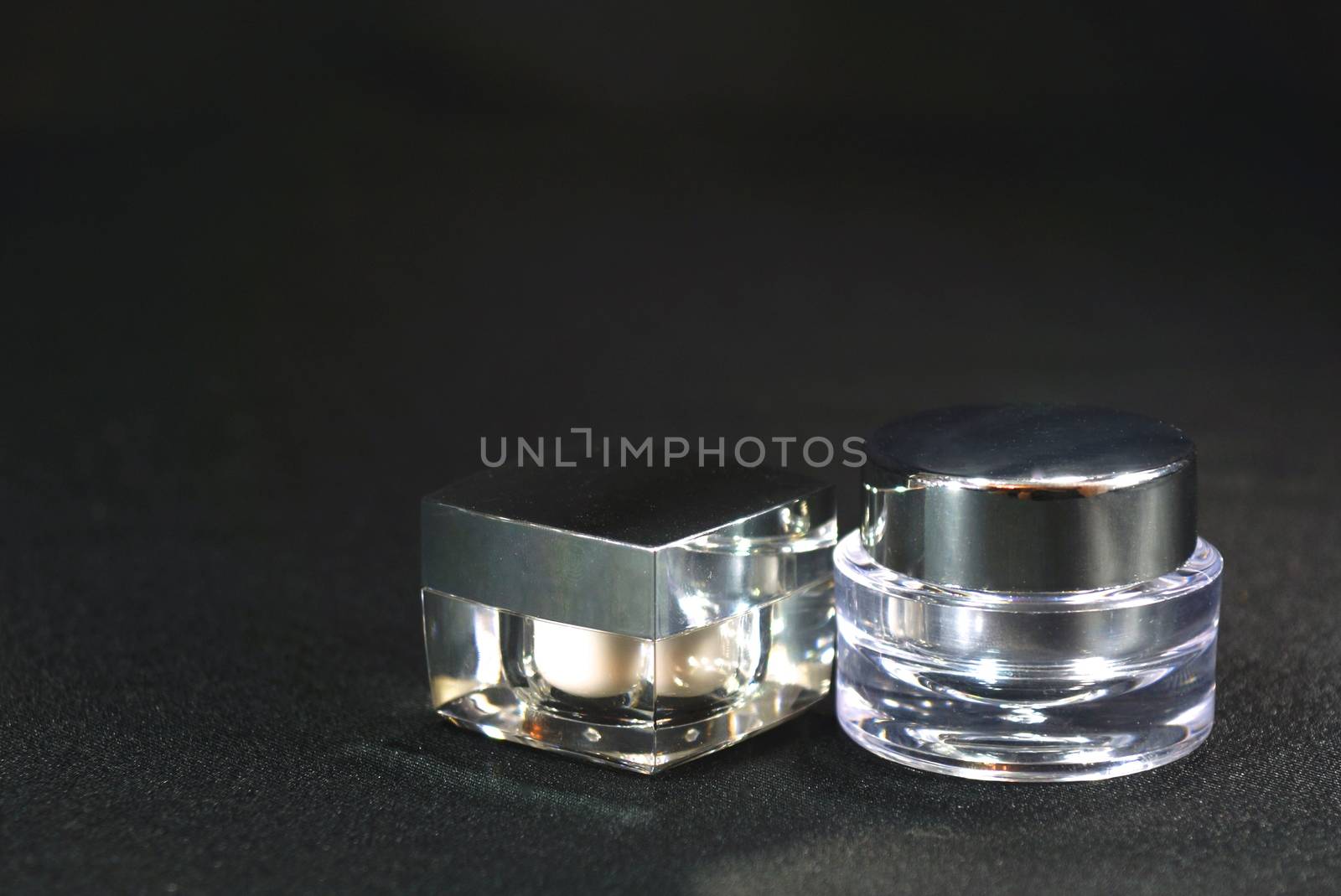 both shaped acrylic cream pot, on black scene,shallow focus