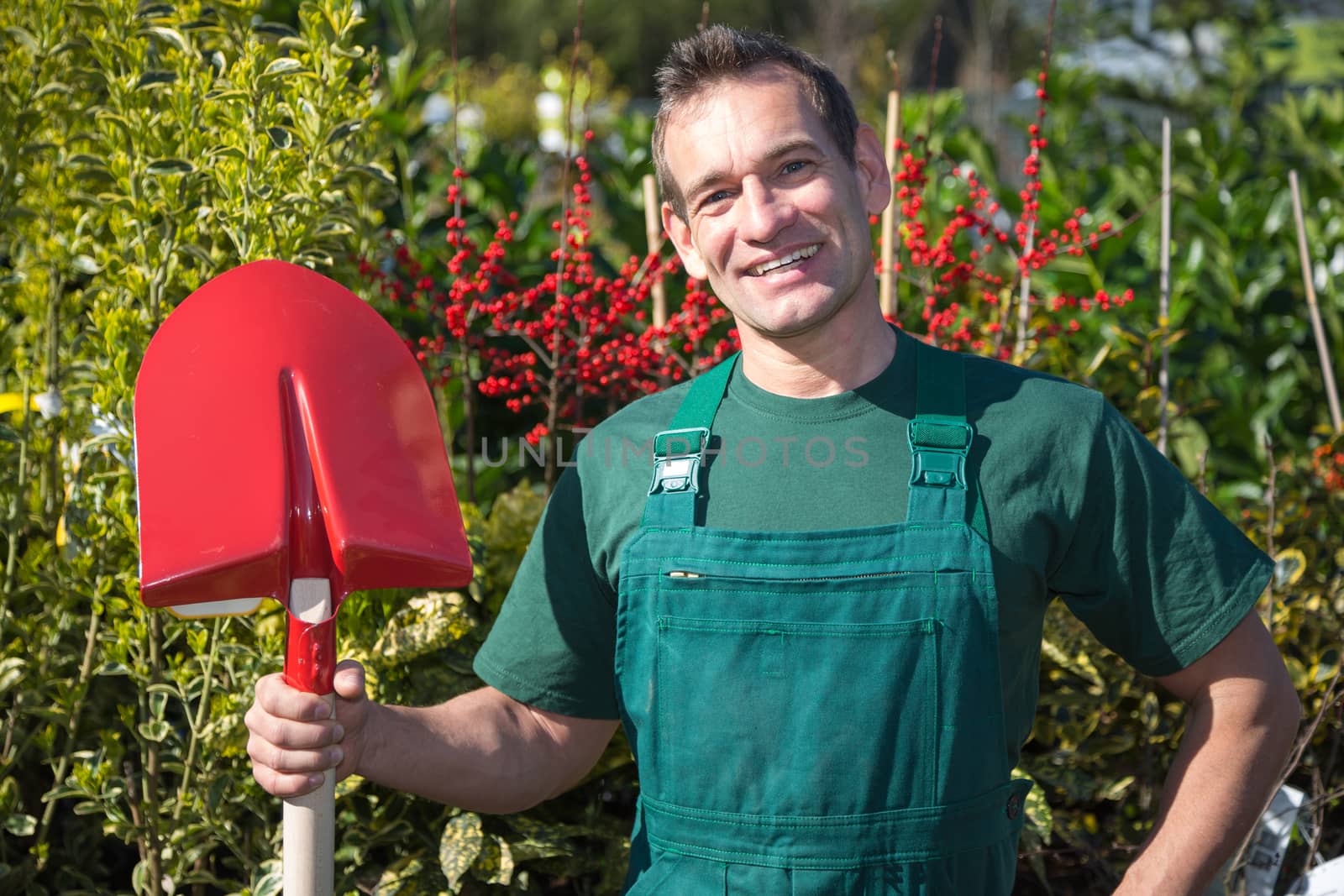 Farmer or gardener posing with shovel in garden by ikonoklast_fotografie