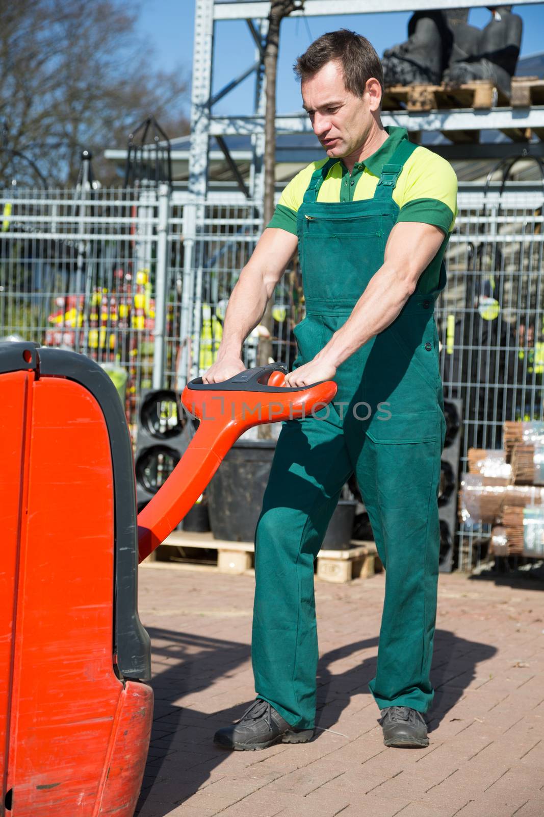 Worker with forklift at warehouse or storehouse
