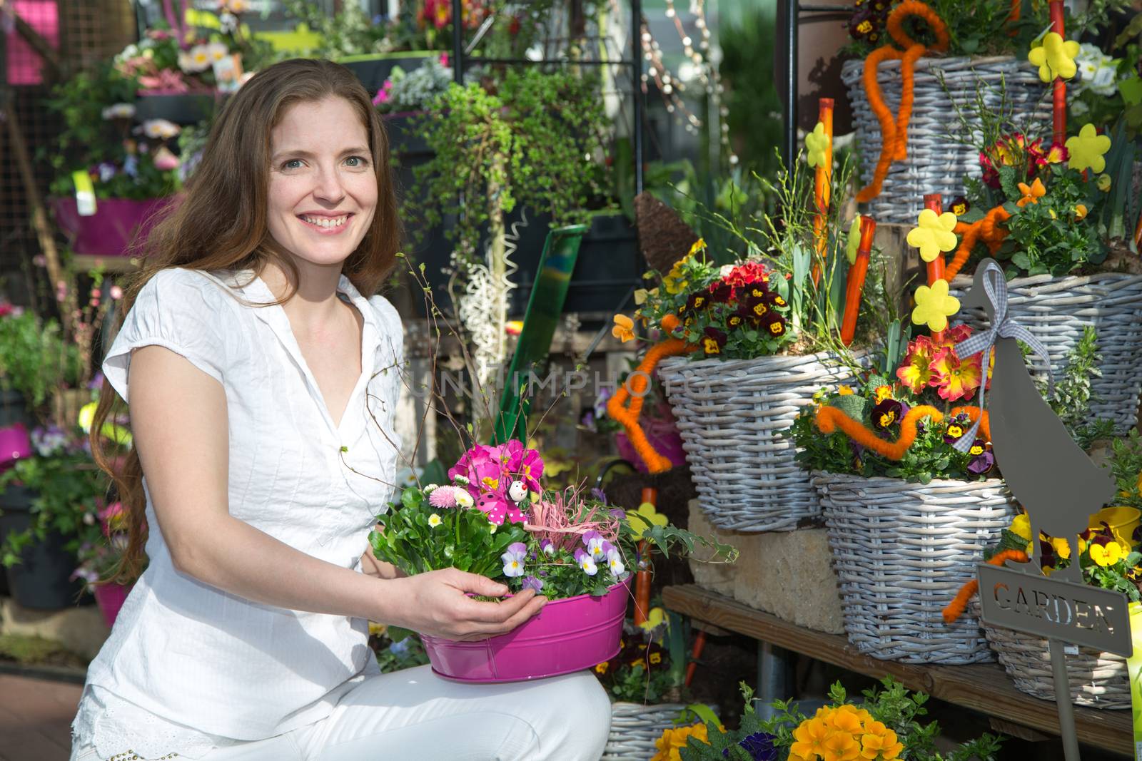 Woman in flower shop among many flower arrangements