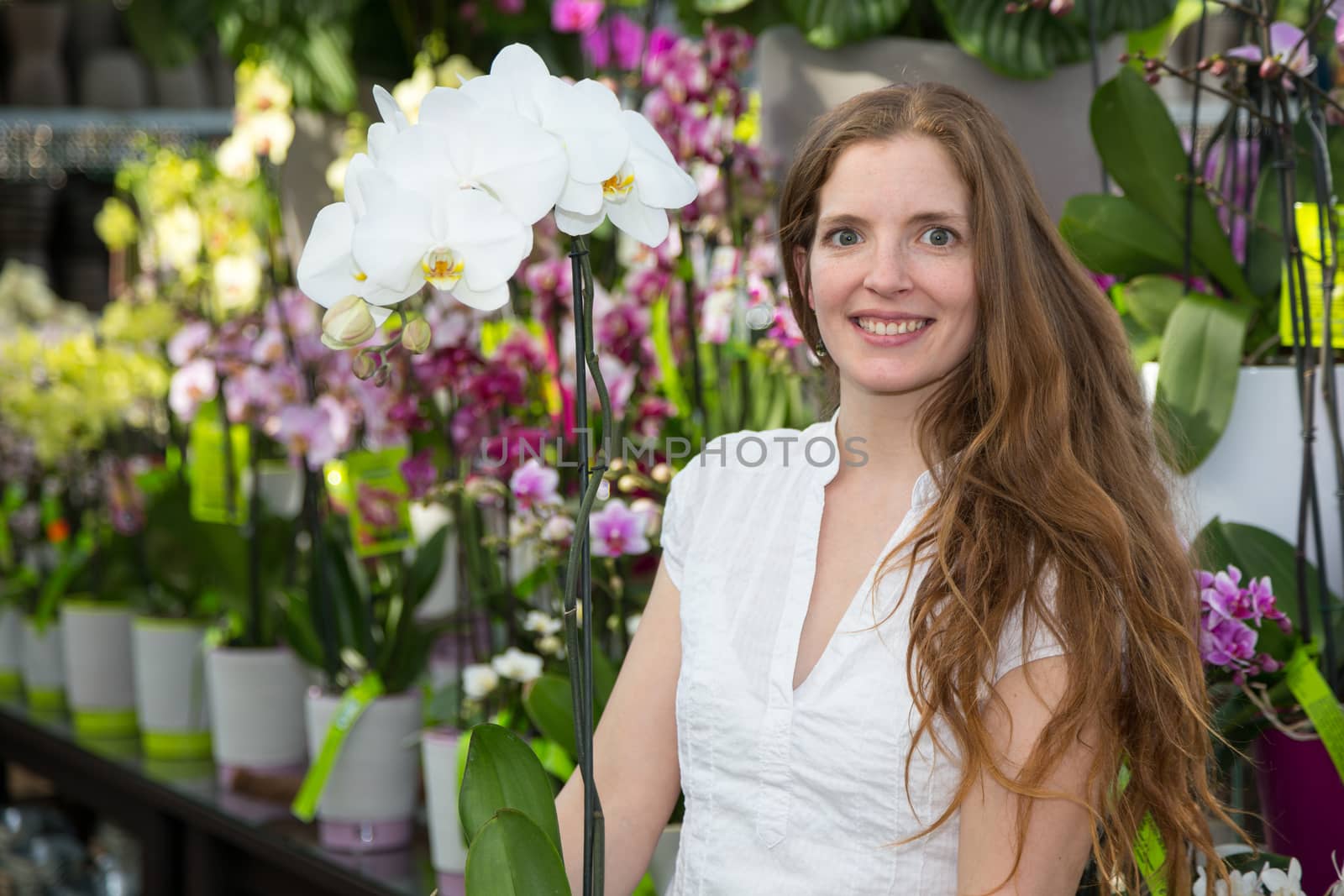 Customer in flower shop posing with orchid by ikonoklast_fotografie