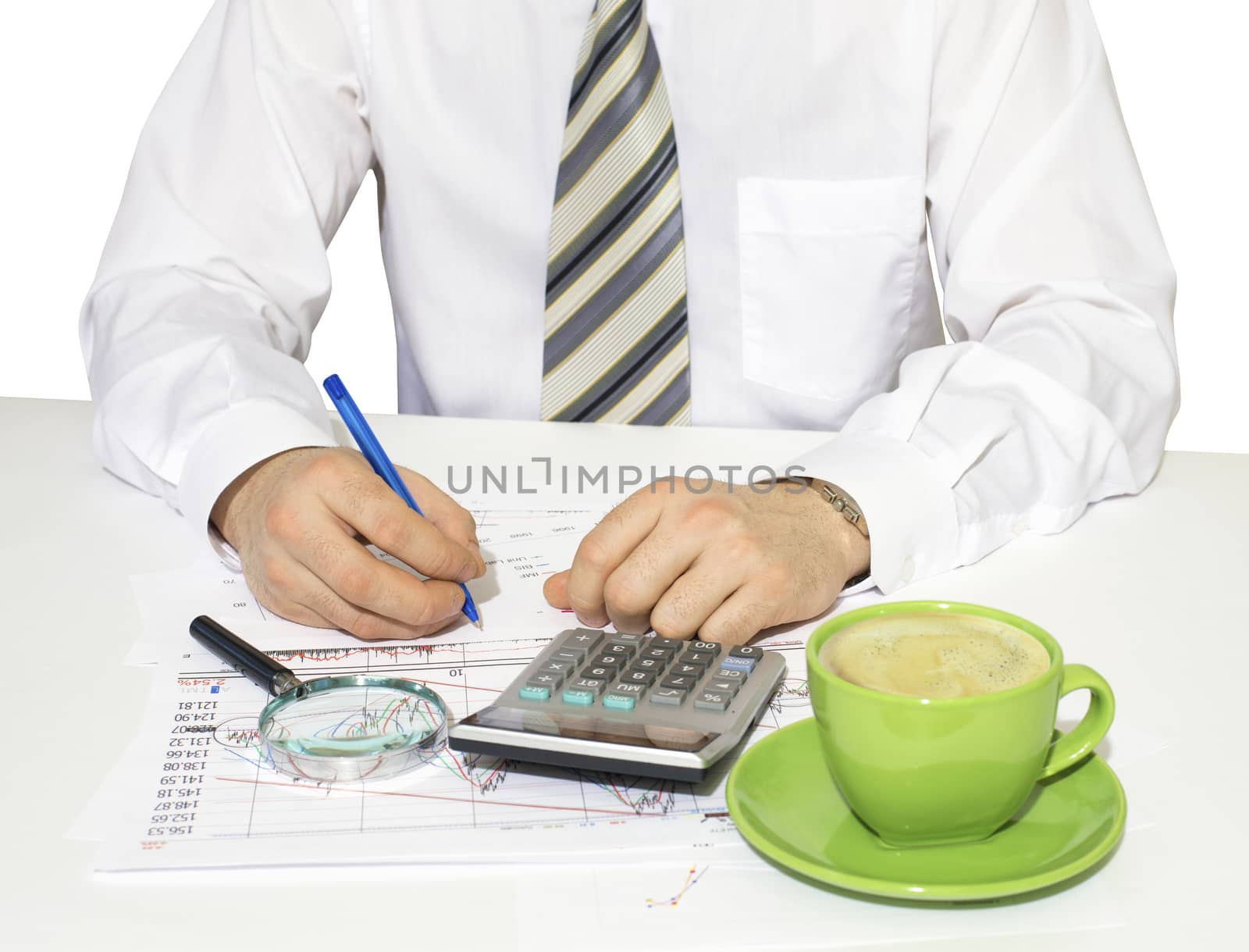 Businessman sitting at a table and writes. Financial papers in front of him