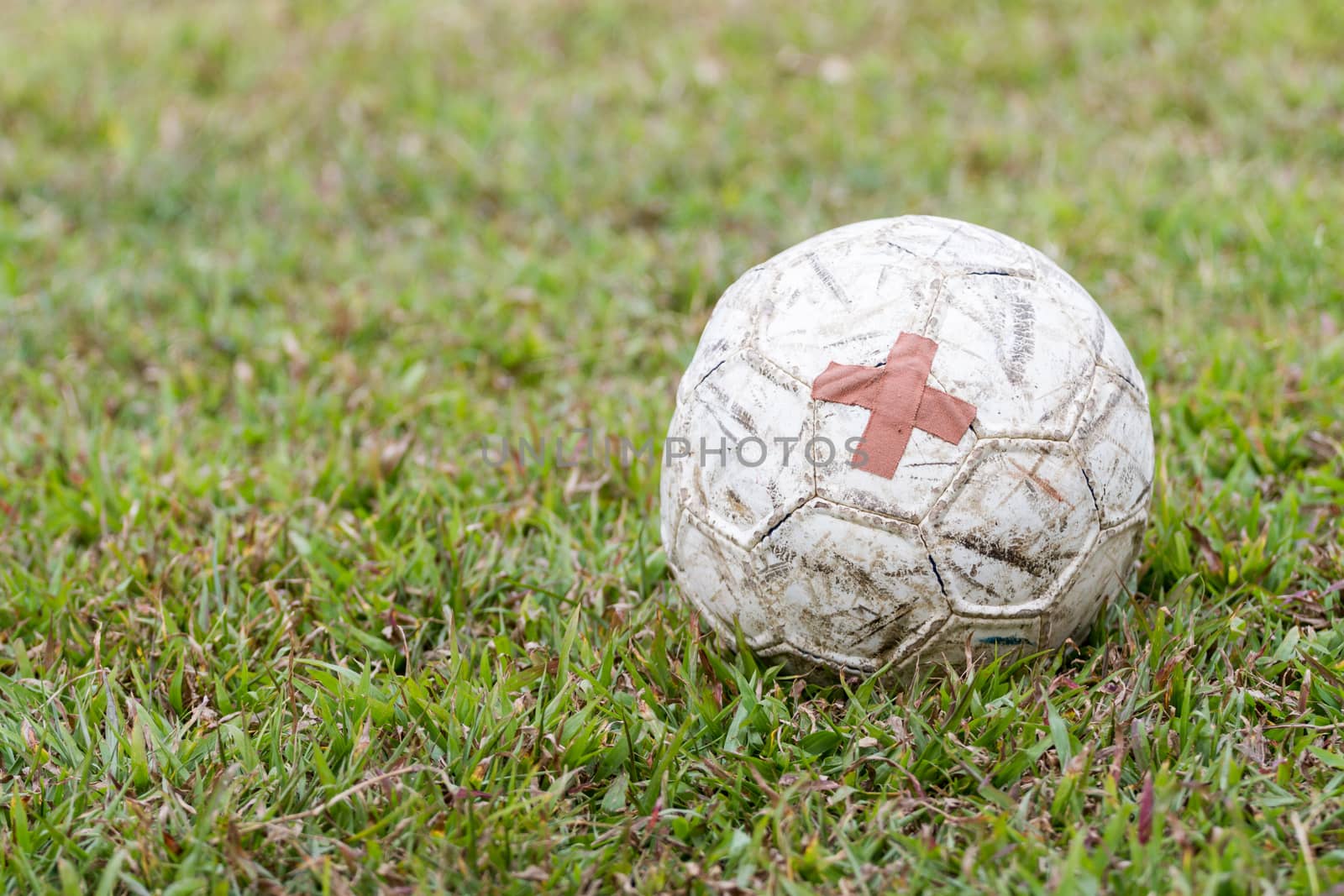 old football with patched on field with blurred background