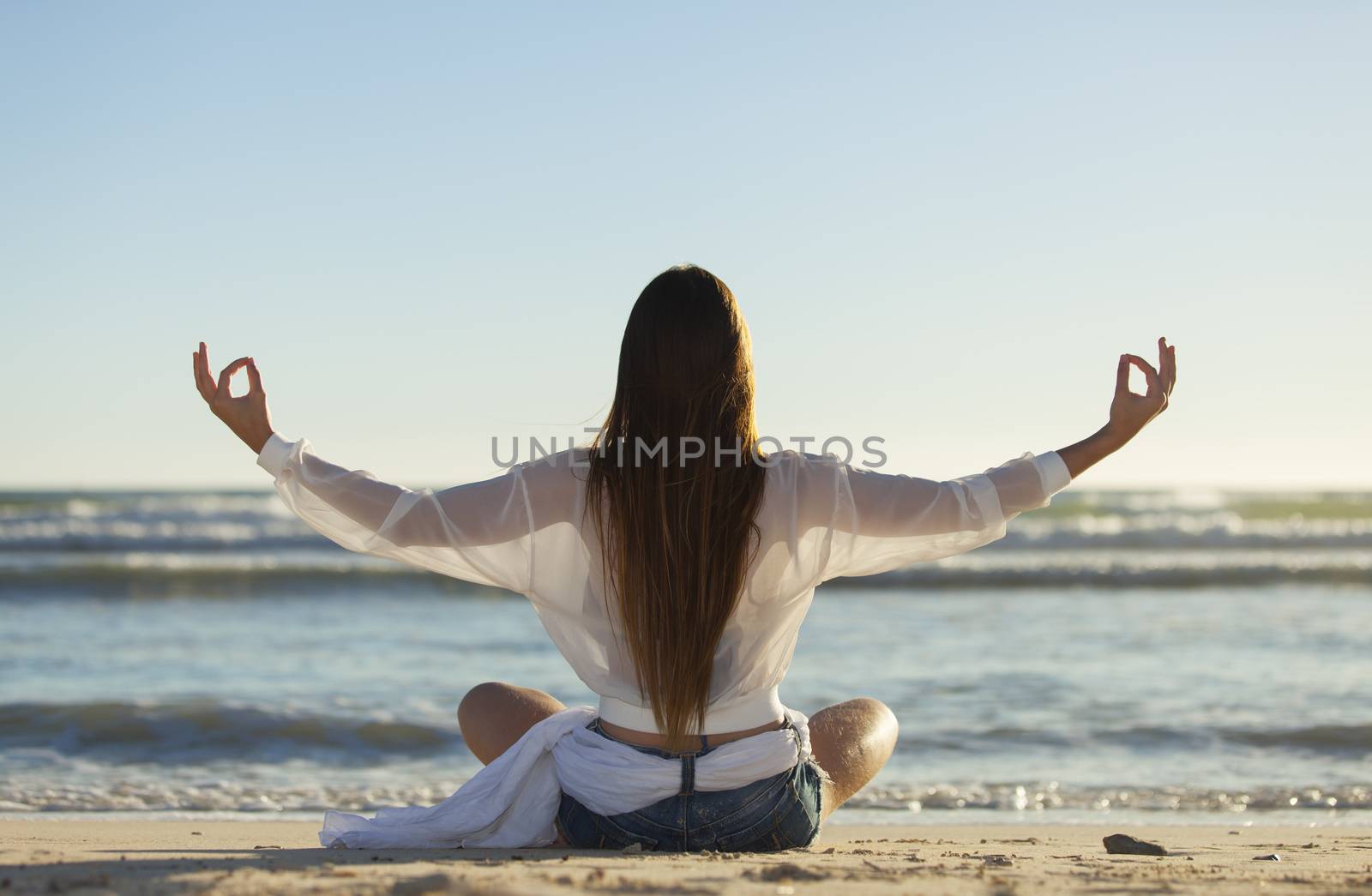 woman doing yoga on a beach by bernjuer