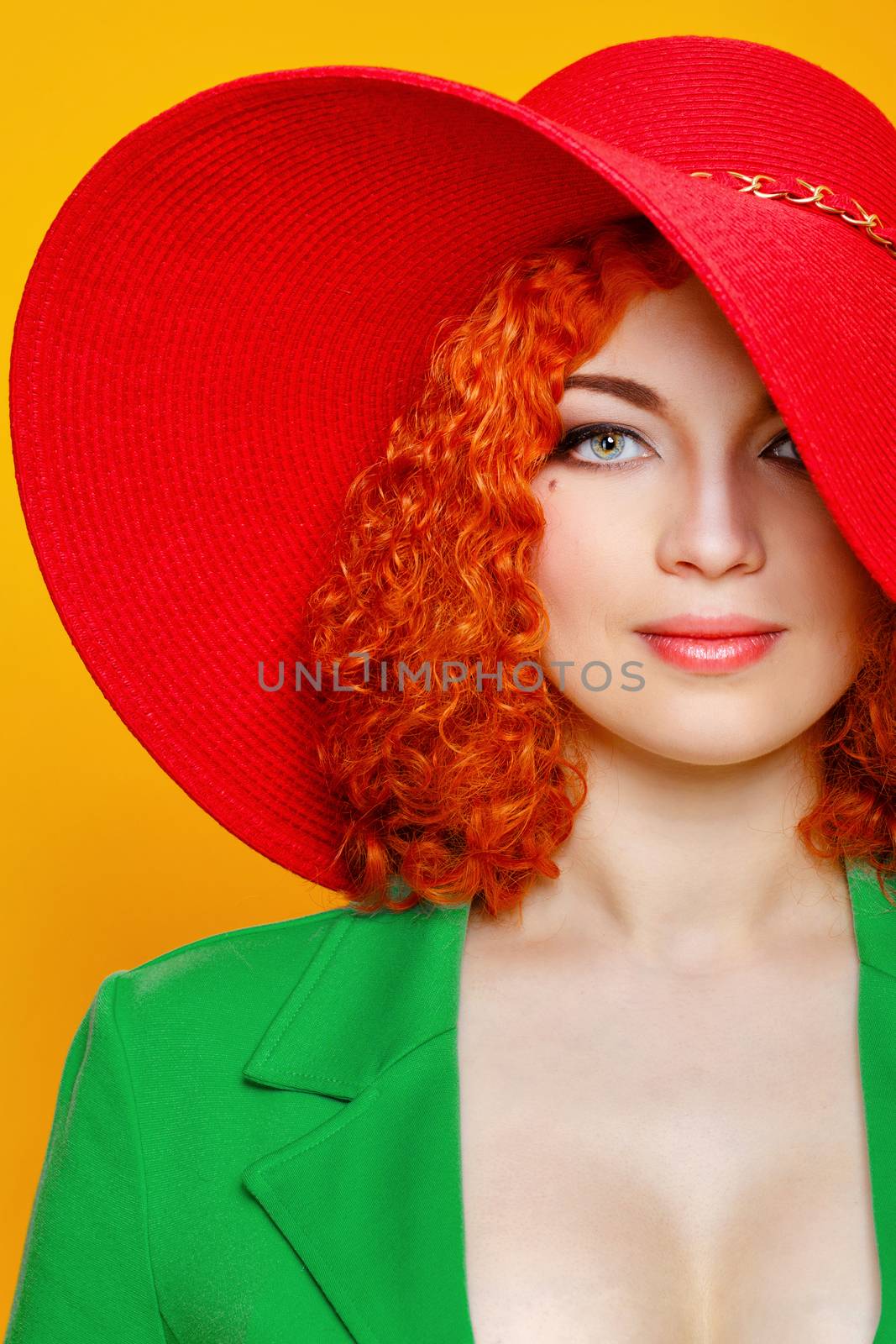 Attractive red-haired girl in red shady hat shot closeup