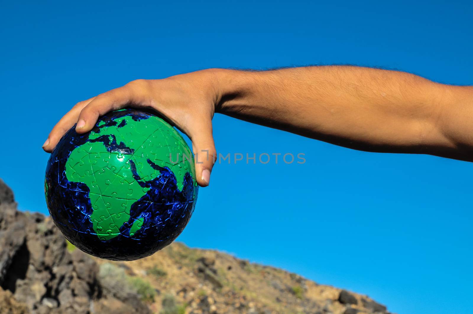 Vintage Old Globe Earth and Human Hand over a Blue Sky
