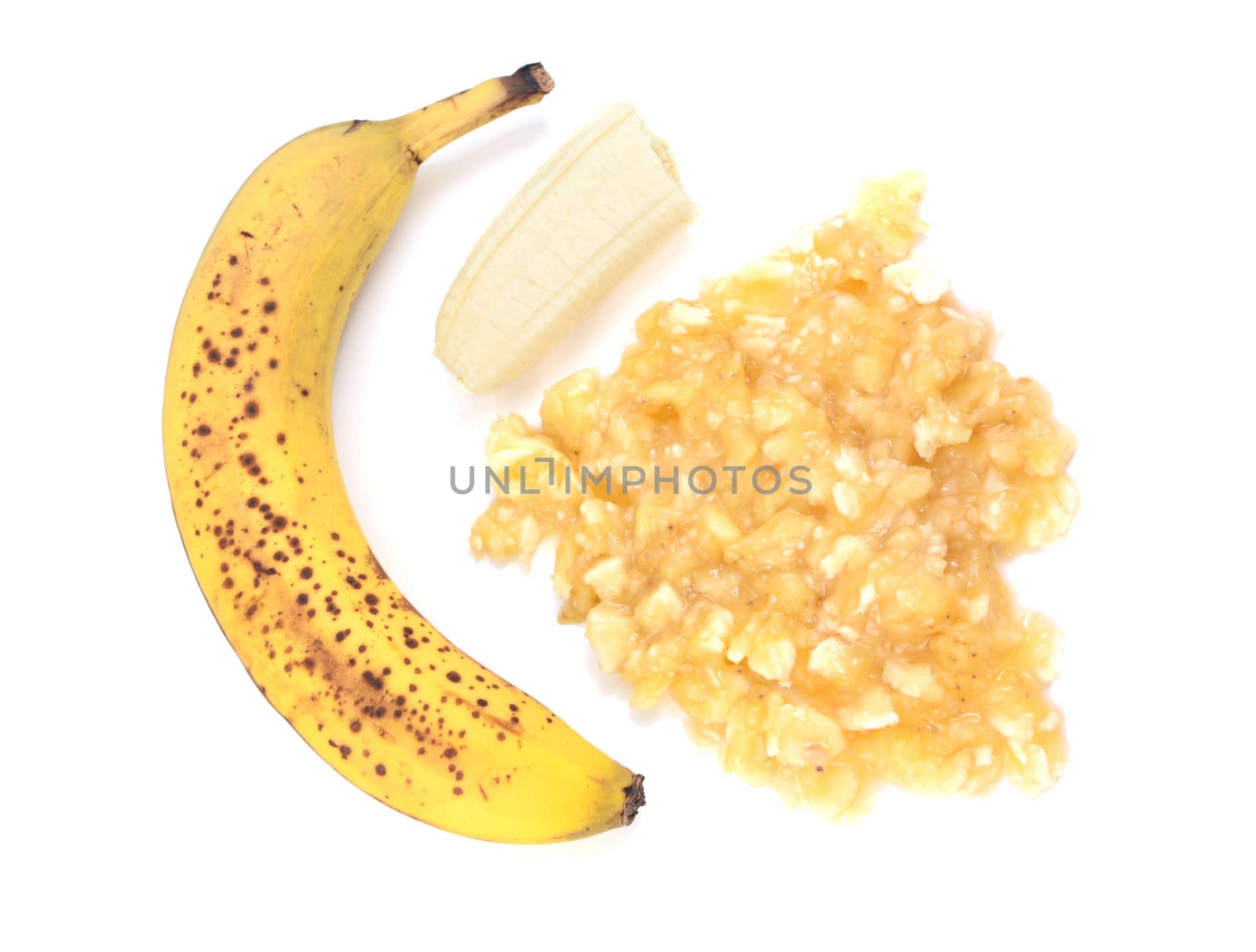 Spotty, overripe banana with whole and mashed fruit, isolated on a white background
