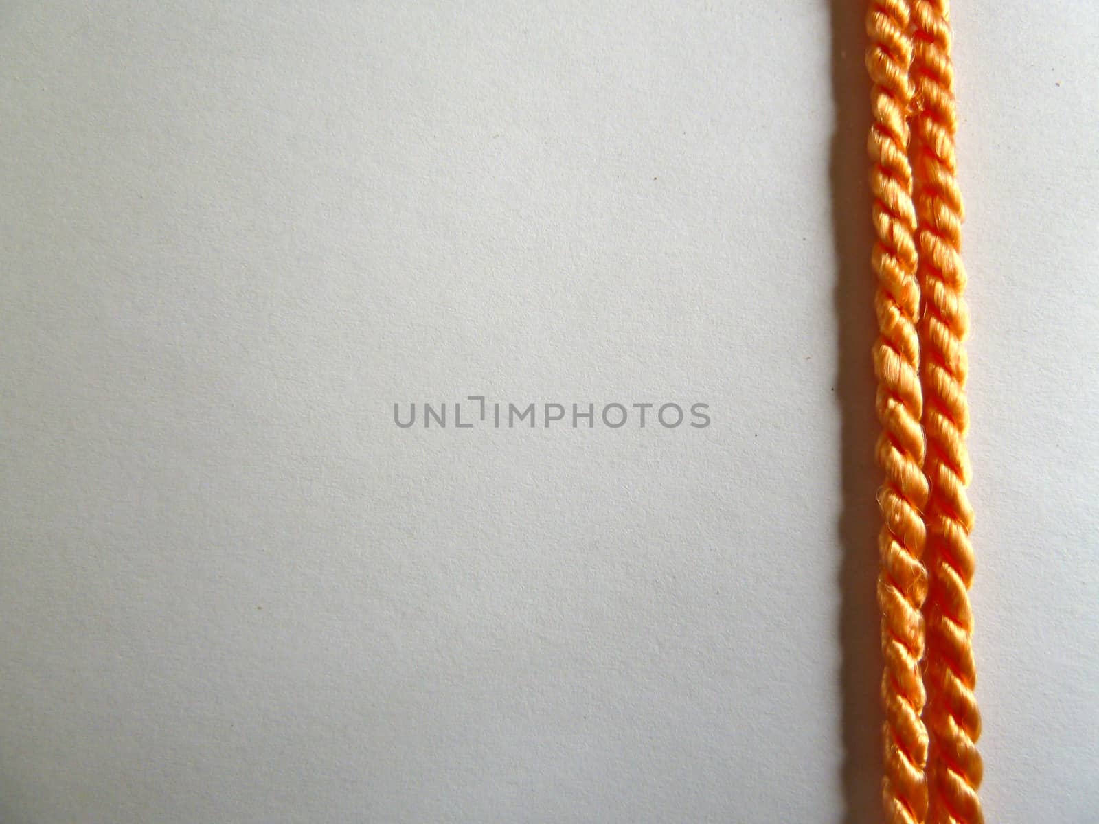 Two bright stripes of golden rope on a white background