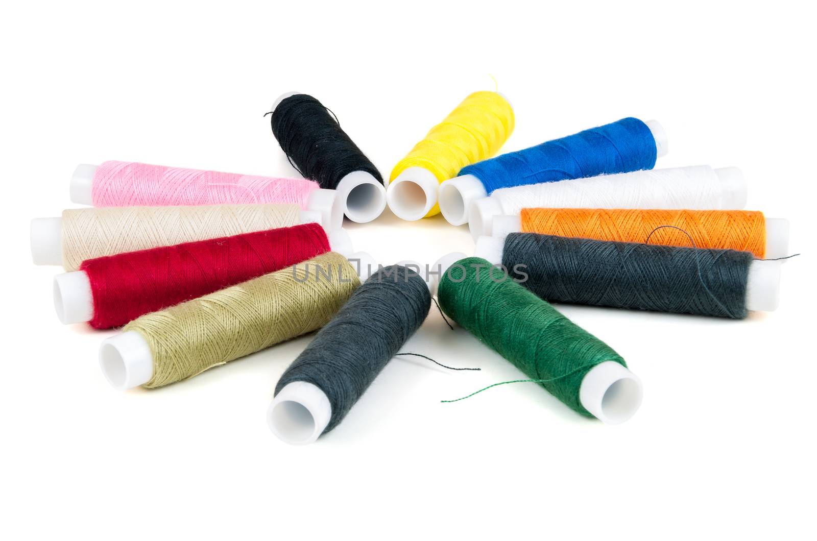 Colored spools of threads on white background by mkos83