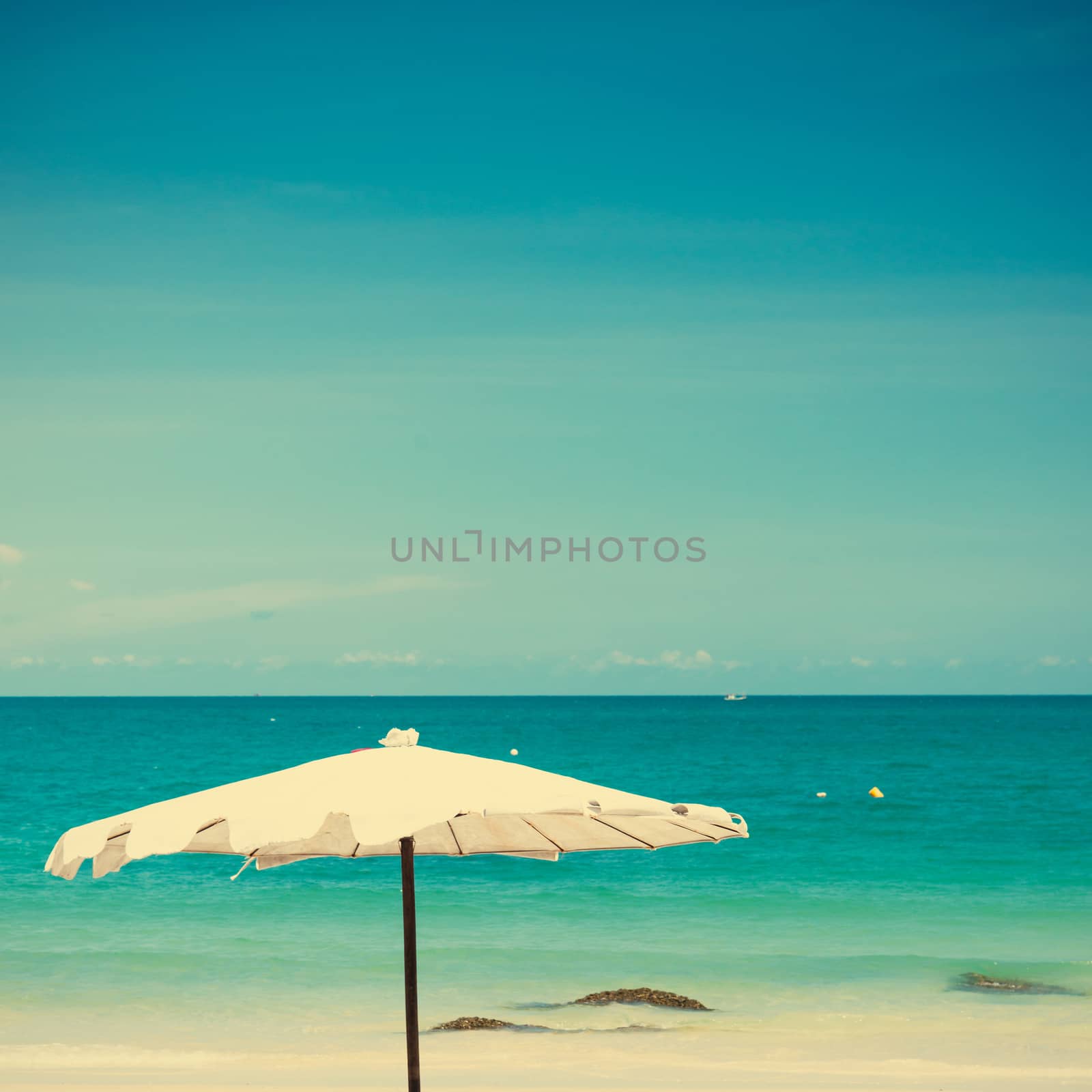 Vintage umbrella on sand beach.  by jakgree