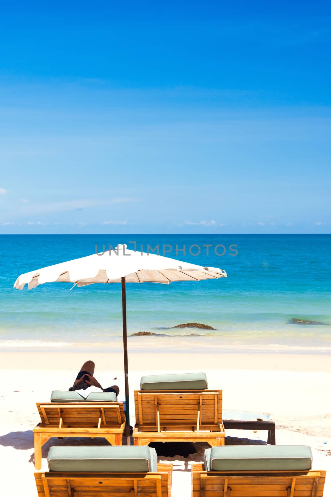 Beach chair and umbrella on sand beach. by jakgree