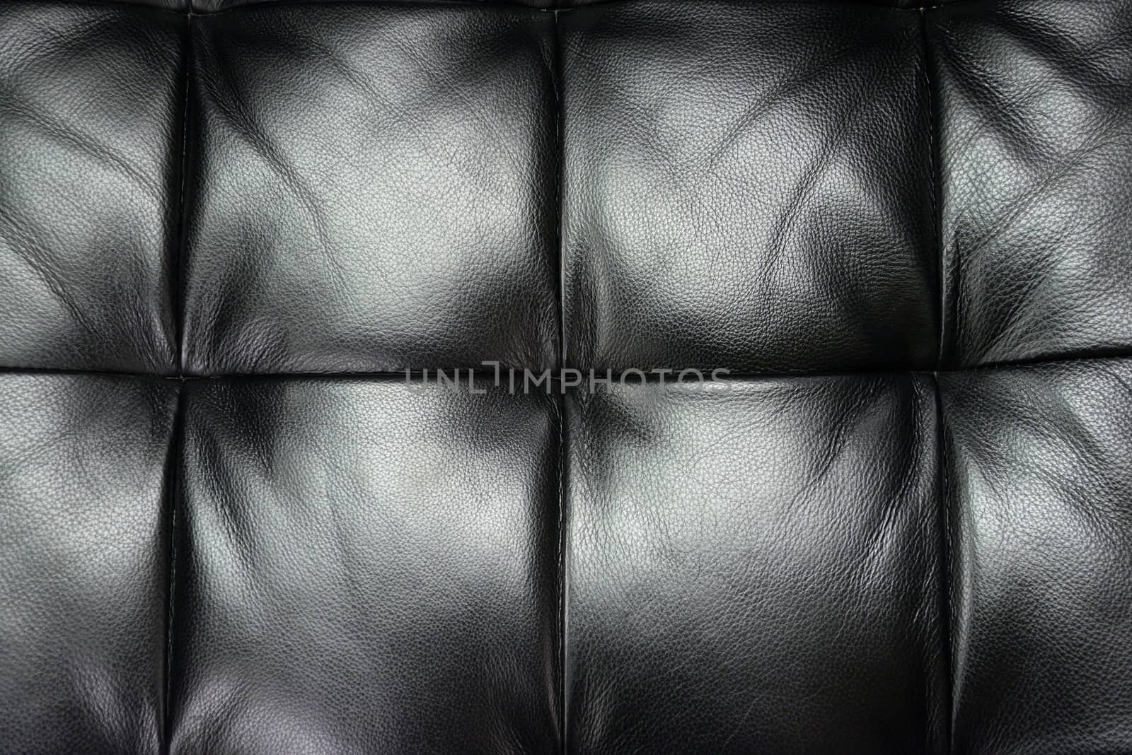 Dark leather texture of sofa closeup shot