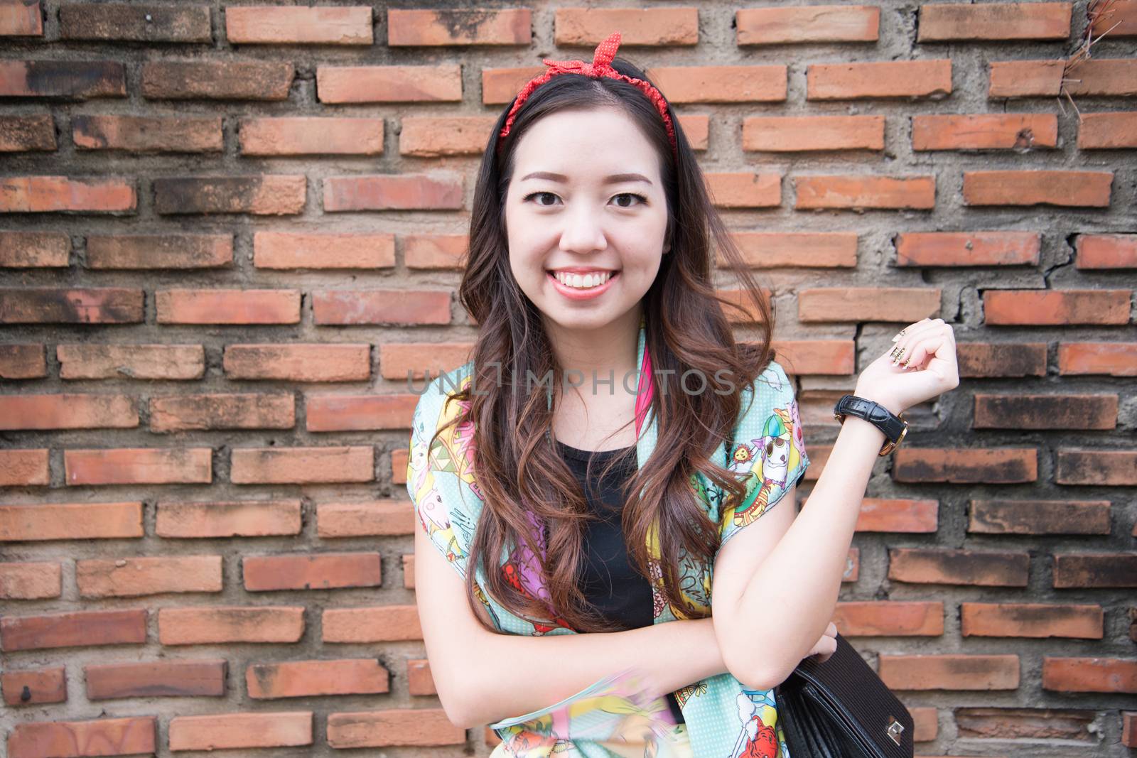 A portrait of beautiful asian woman with brick wall background by jakgree