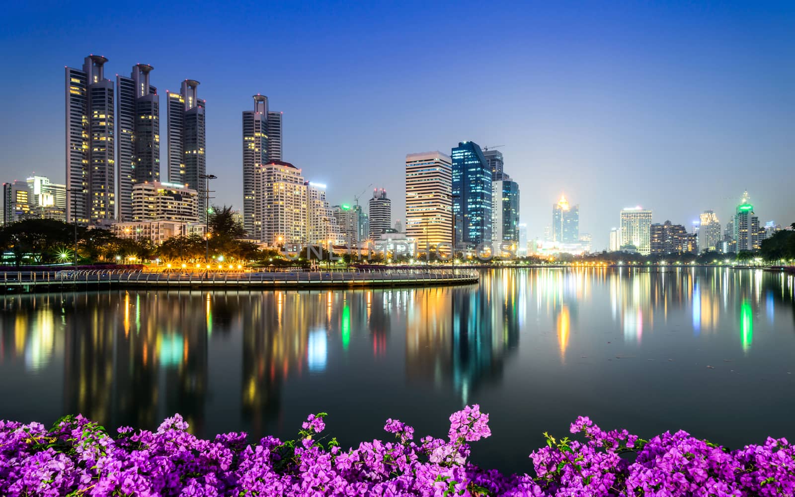 Bangkok city downtown at night with Bougainvillea flower foregro by jakgree