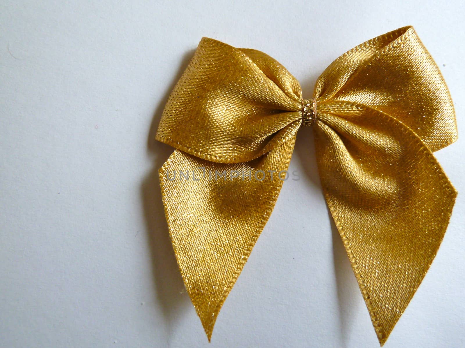 Bright gold ribbon closeup on a white background