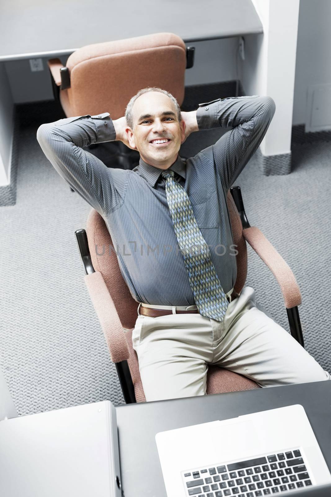 Businessman with laptop computer sitting at office workstation